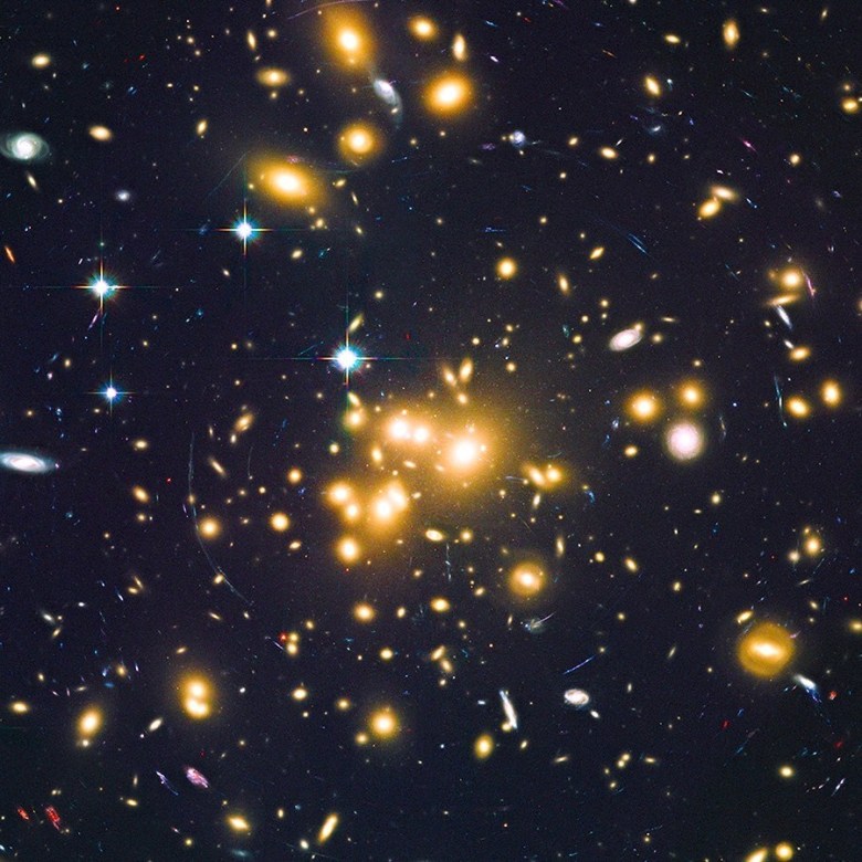 the-cluster-of-galaxies-in-the-middle-work-as-a-natural-lens-producing-streaks-of-light-from-distan